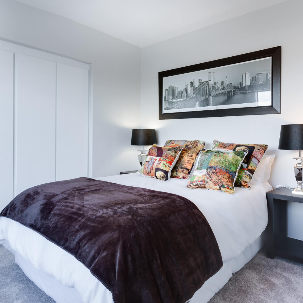 bedroom with white bedding and purple throw