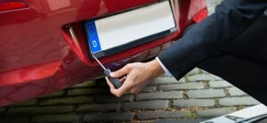Someone removing a car number plate
