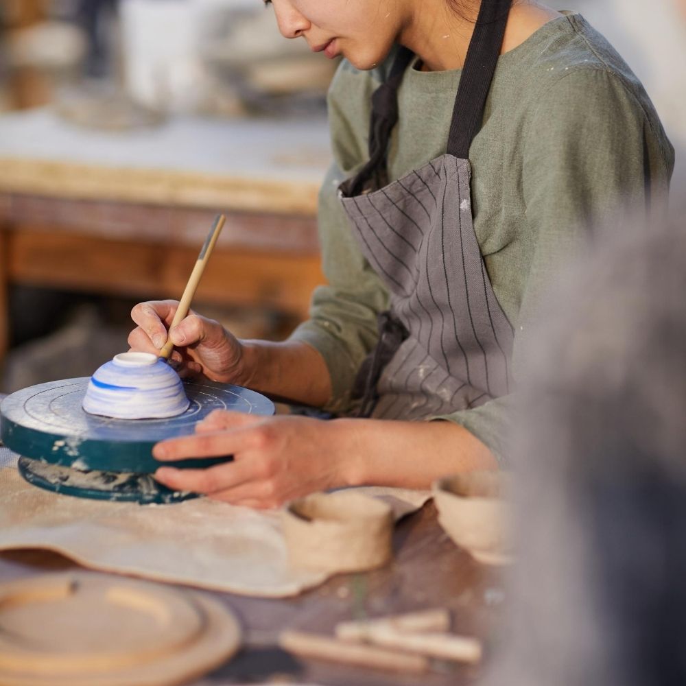 lady painting a ceramic bowl