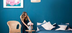 person position a flower vase in a blue room