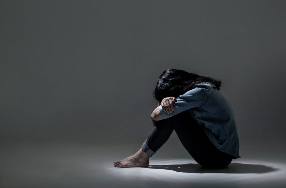 women with her head in her arms.
