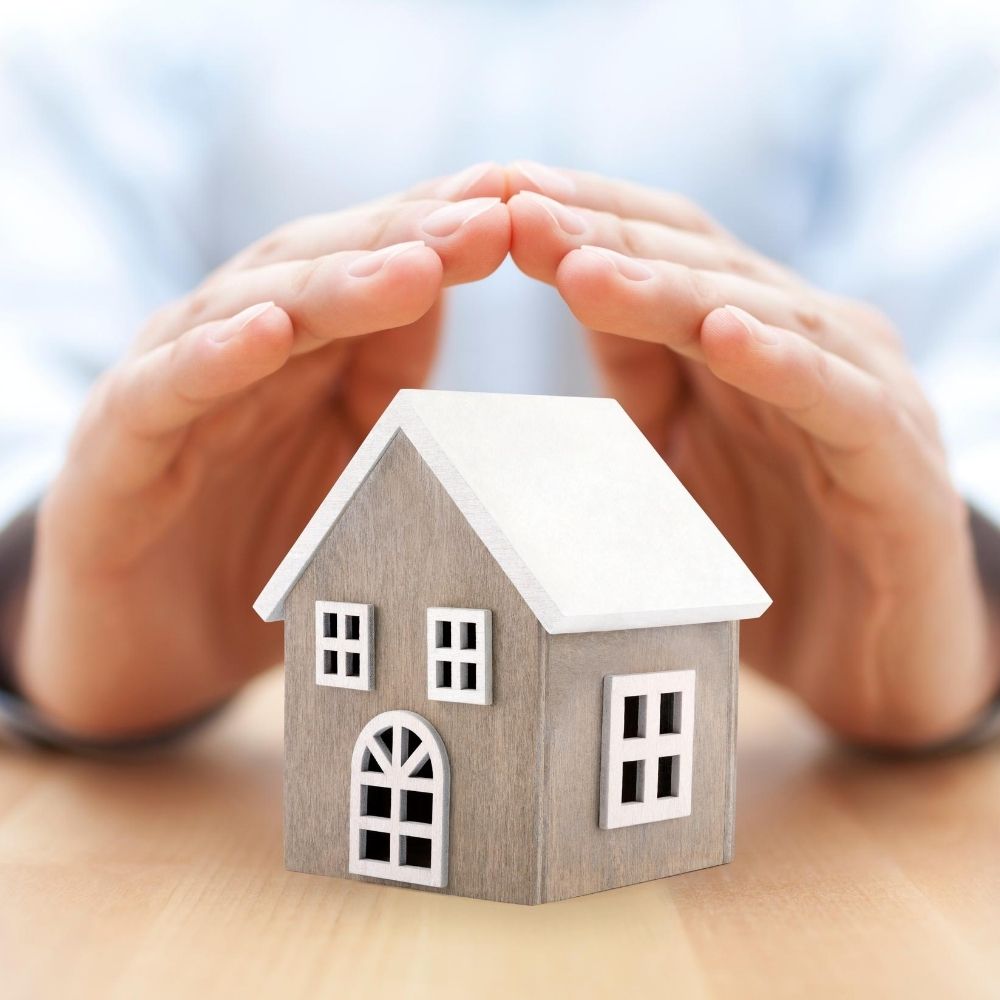 hands over a model house
