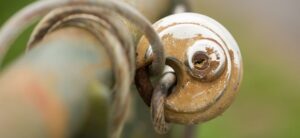 round rusted padlock locked a metal pole