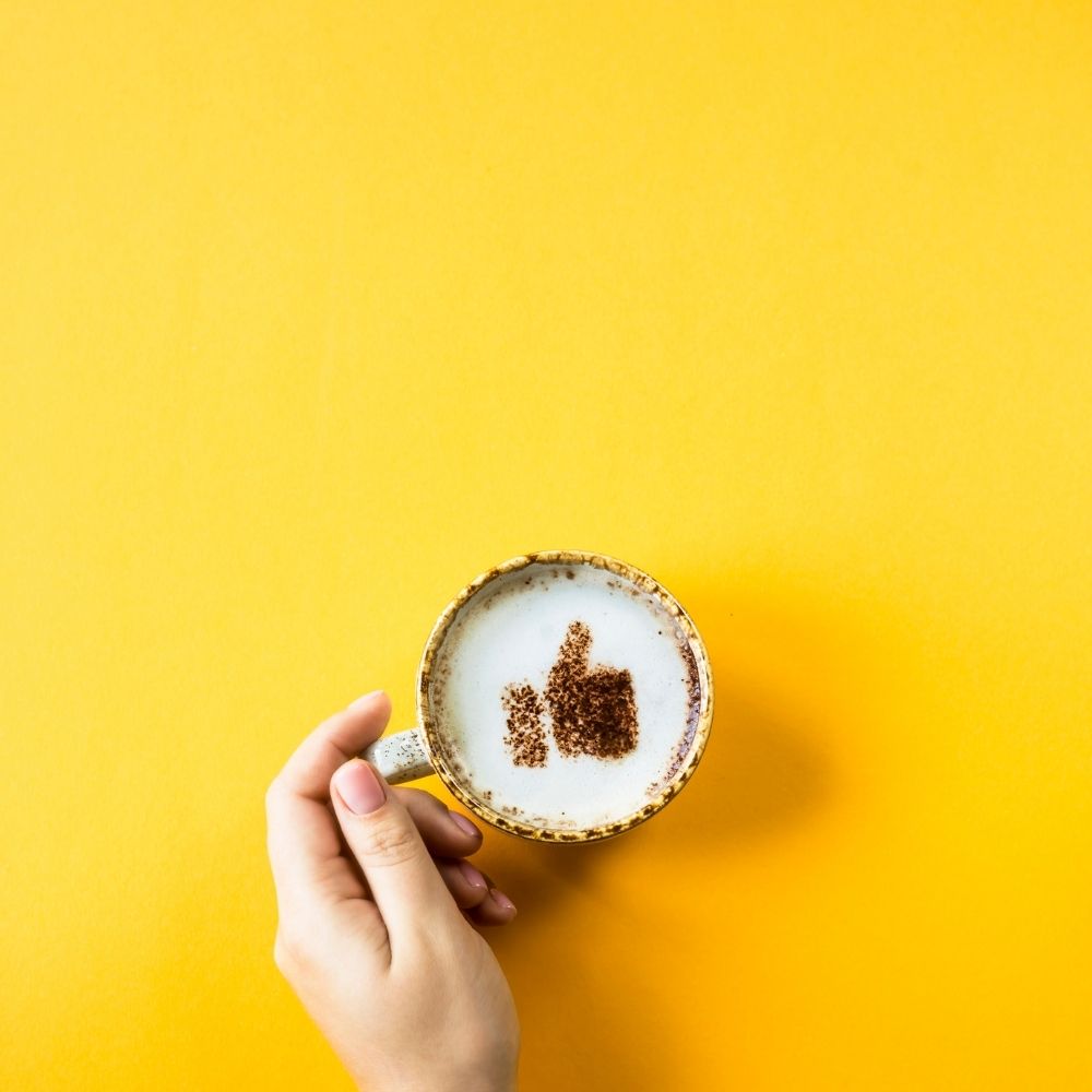 thumbs up on a cup of coffee