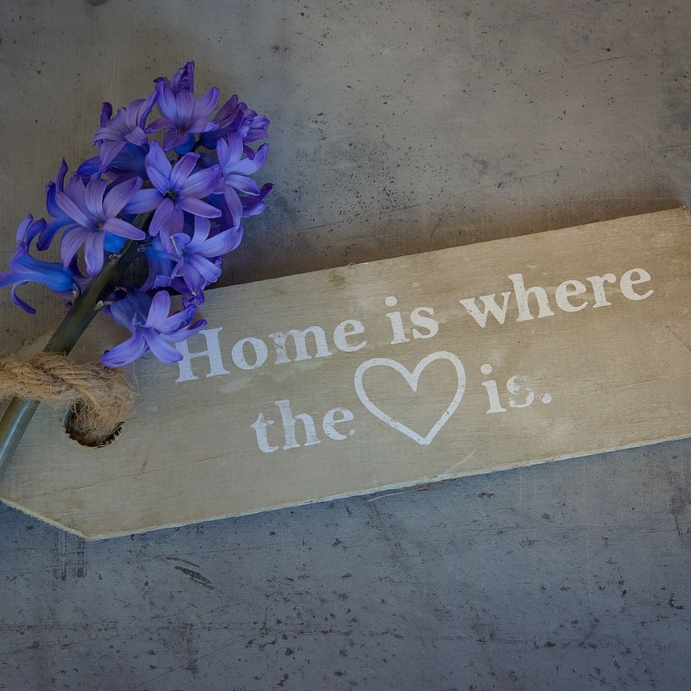 wooden home decoration with a small bunch of purple flowers