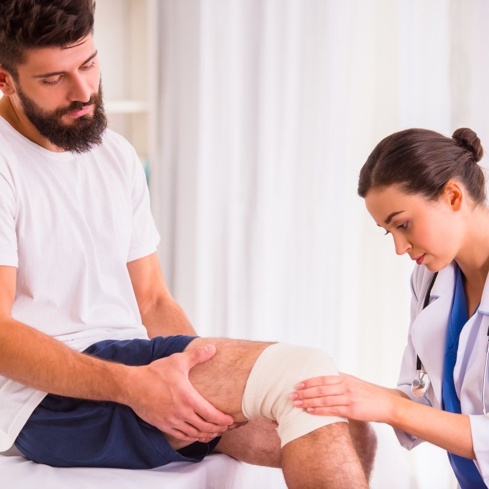 doctor looking at someone who has an injured knee