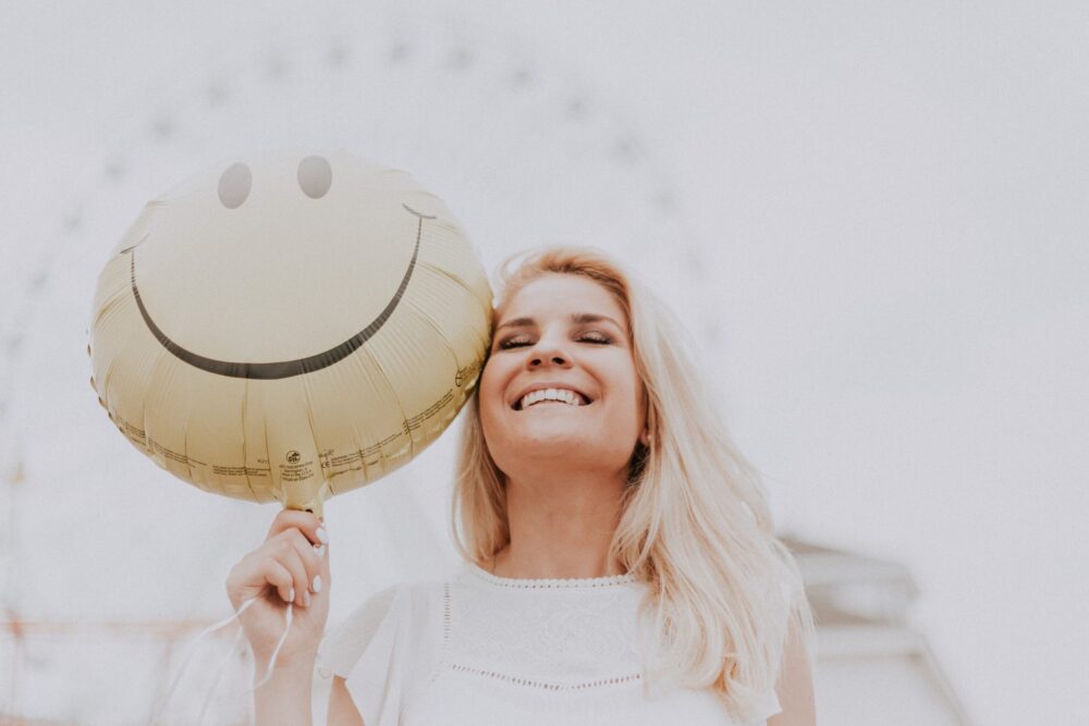 Women holiday a smiley face balloon