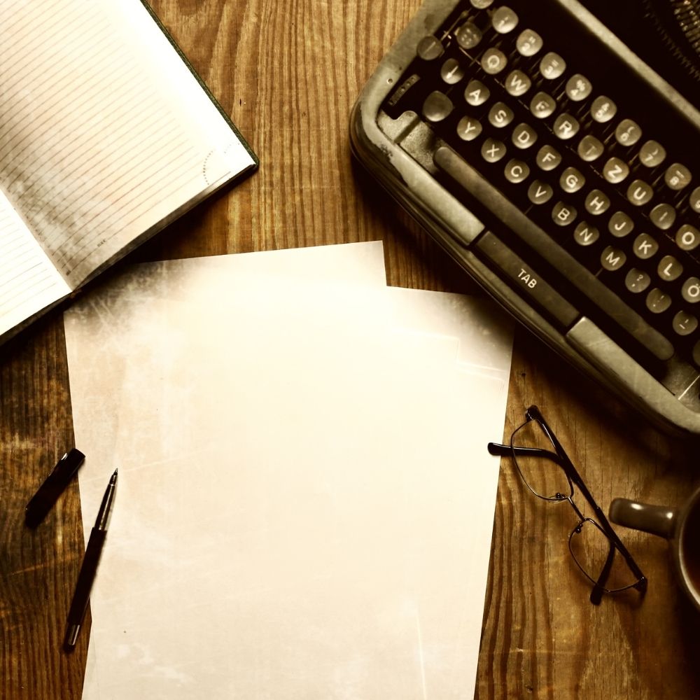 typewriter paper notebook and glasses