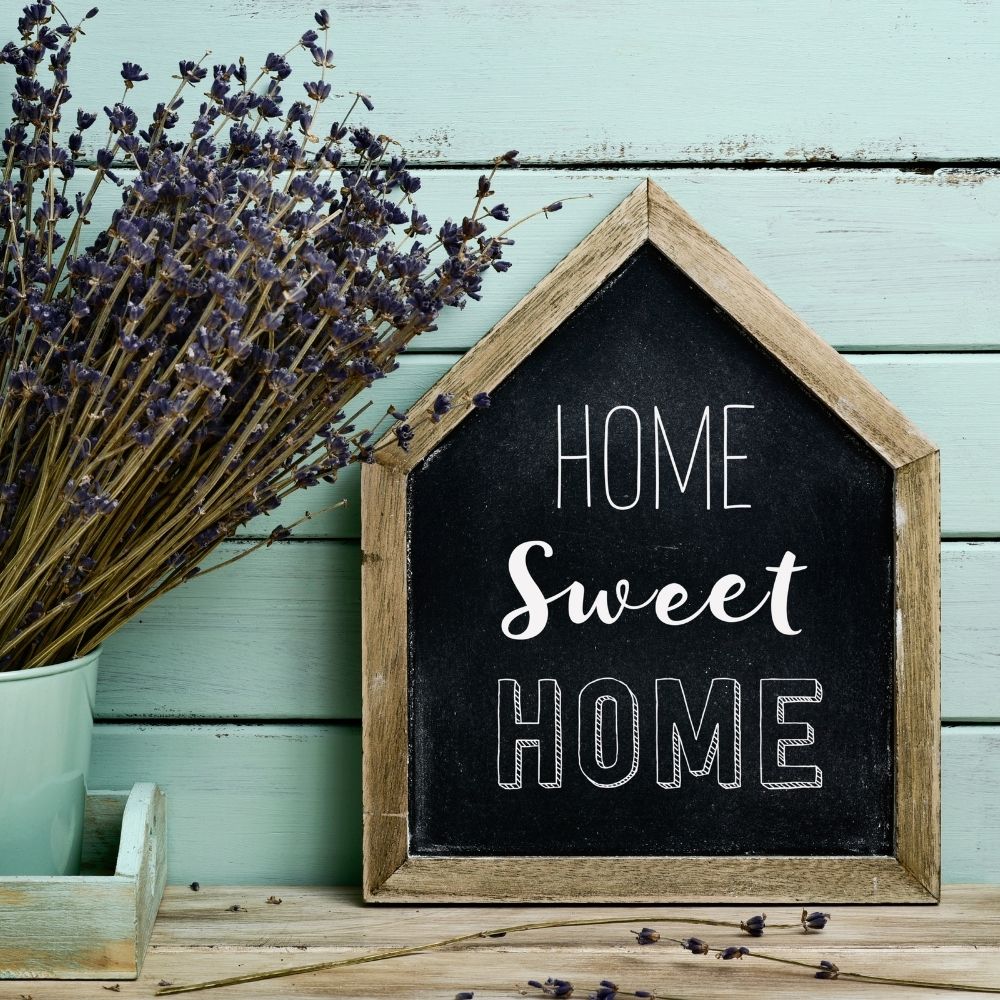 sign that says home sweet home with lavender beside it