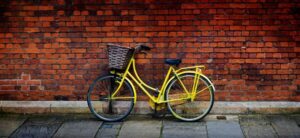 yellow bike up against a brick wall