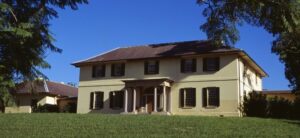 large house surrounded by grass and trees