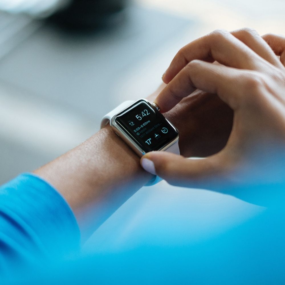 person wearing a blue top setting activity levels on their smart watch