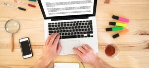 person working on a blog post on their laptop