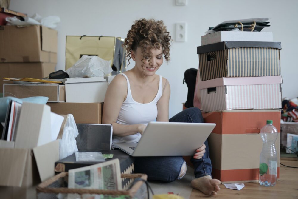 Women working on a computer surrounded by boxes