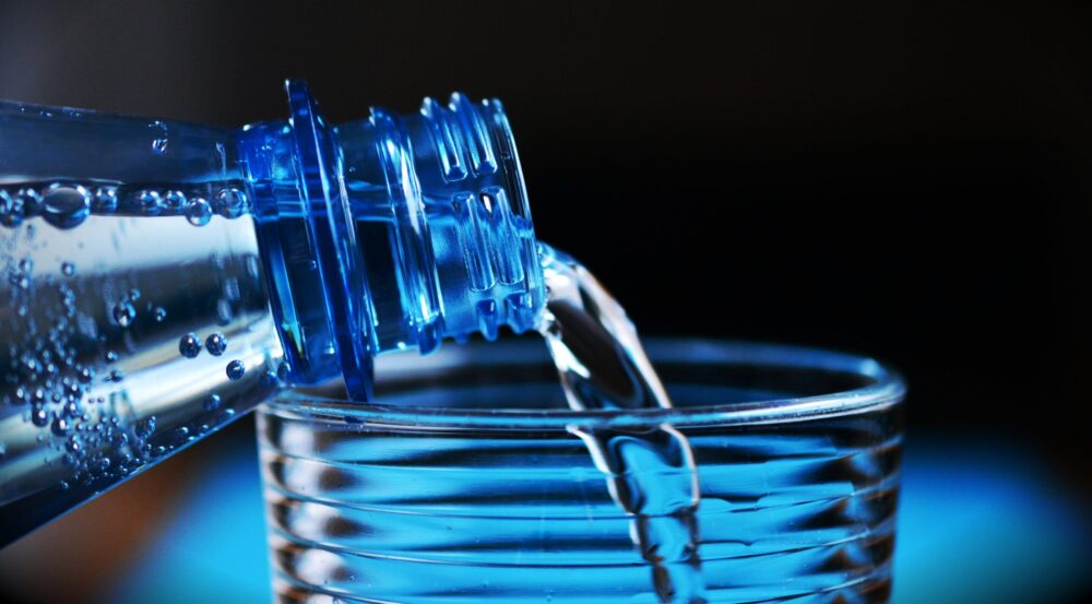 water being poured into a glass from a bottle