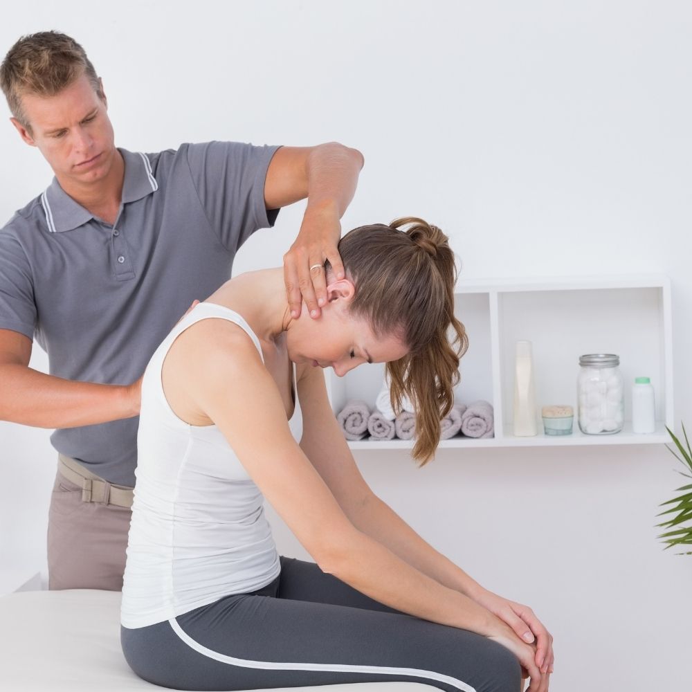 Chiropractor looking at a womens back and neck area