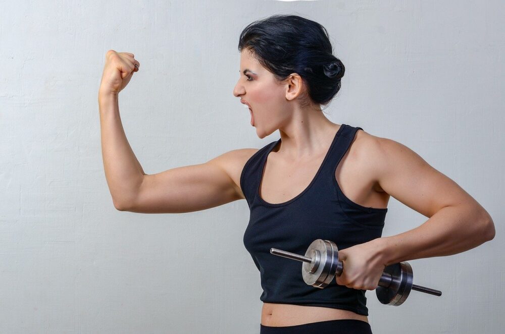 women in workout clothing holding weights