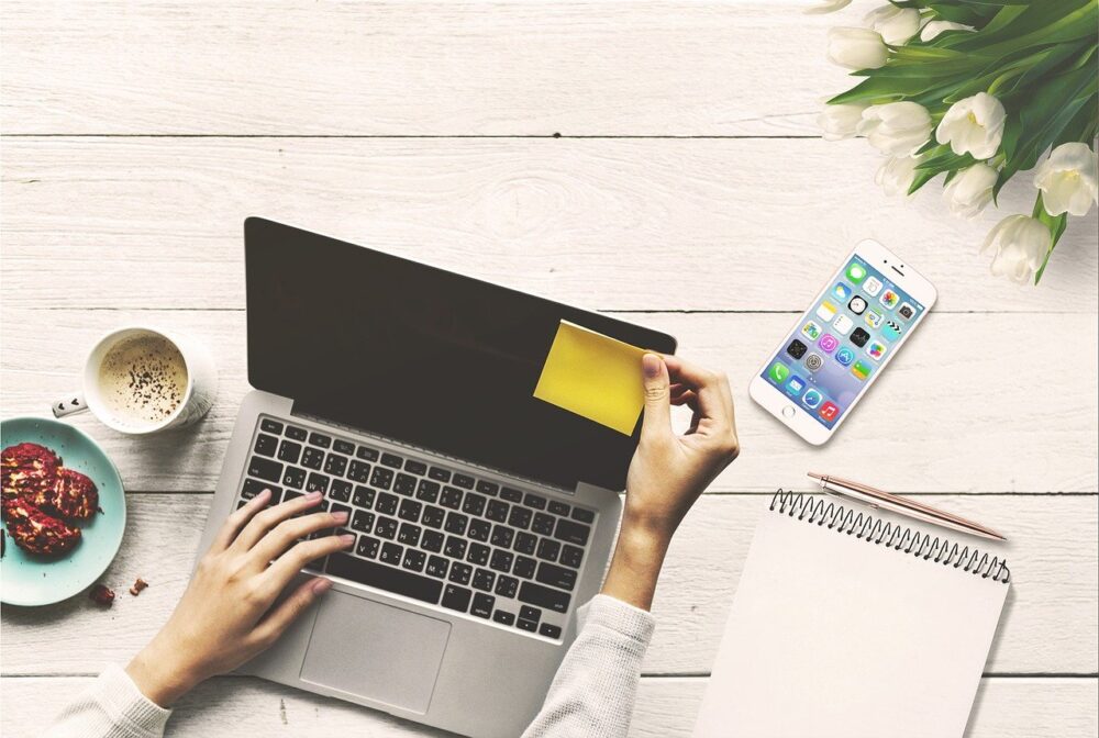 Image of some putting a yellow sticky note on their computer