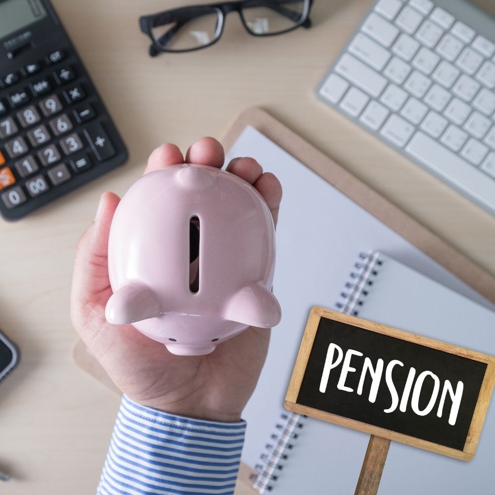 person holding a piggybank with calculator and keyboard behind and the word pension