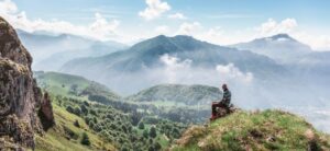 picture of a person sat on a hill spending time alone
