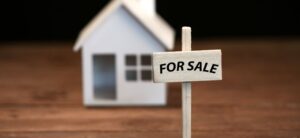 small model house with for sale sign outside