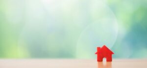 small red house shape sat on a table with green background