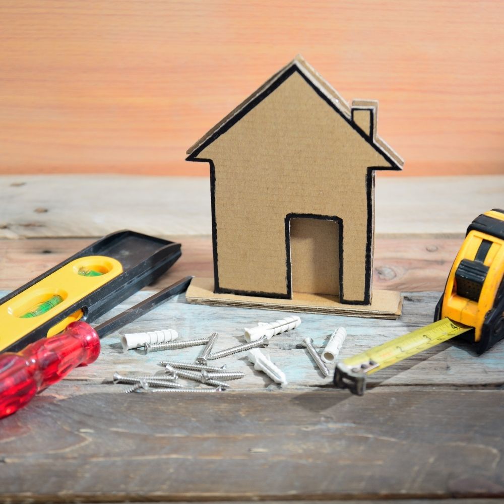 DIY tools sat around a wooden model of a house