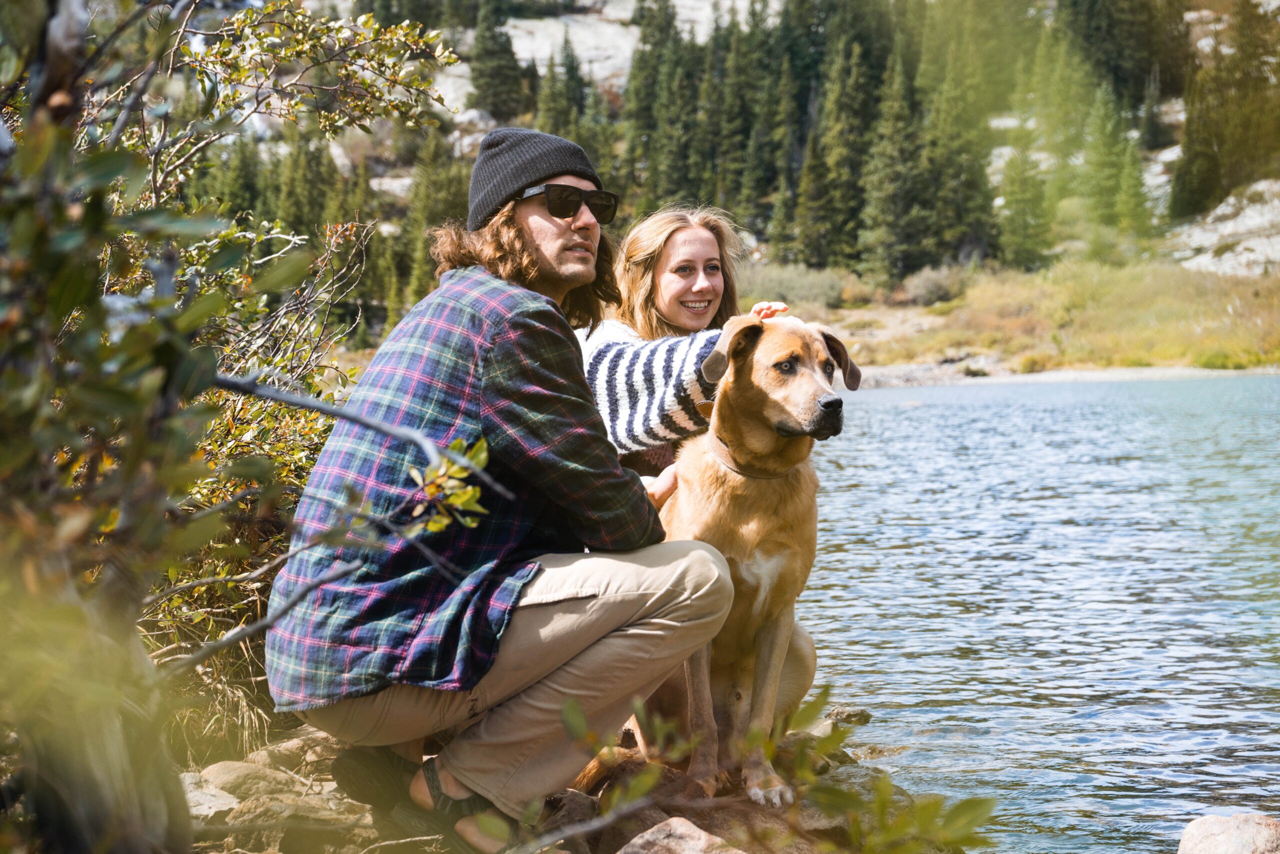 Man, women and dog sat by a river side