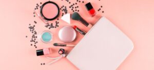 make up bag with products coming out on peach background
