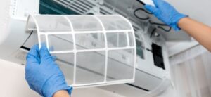 person cleaning out an air conditioner