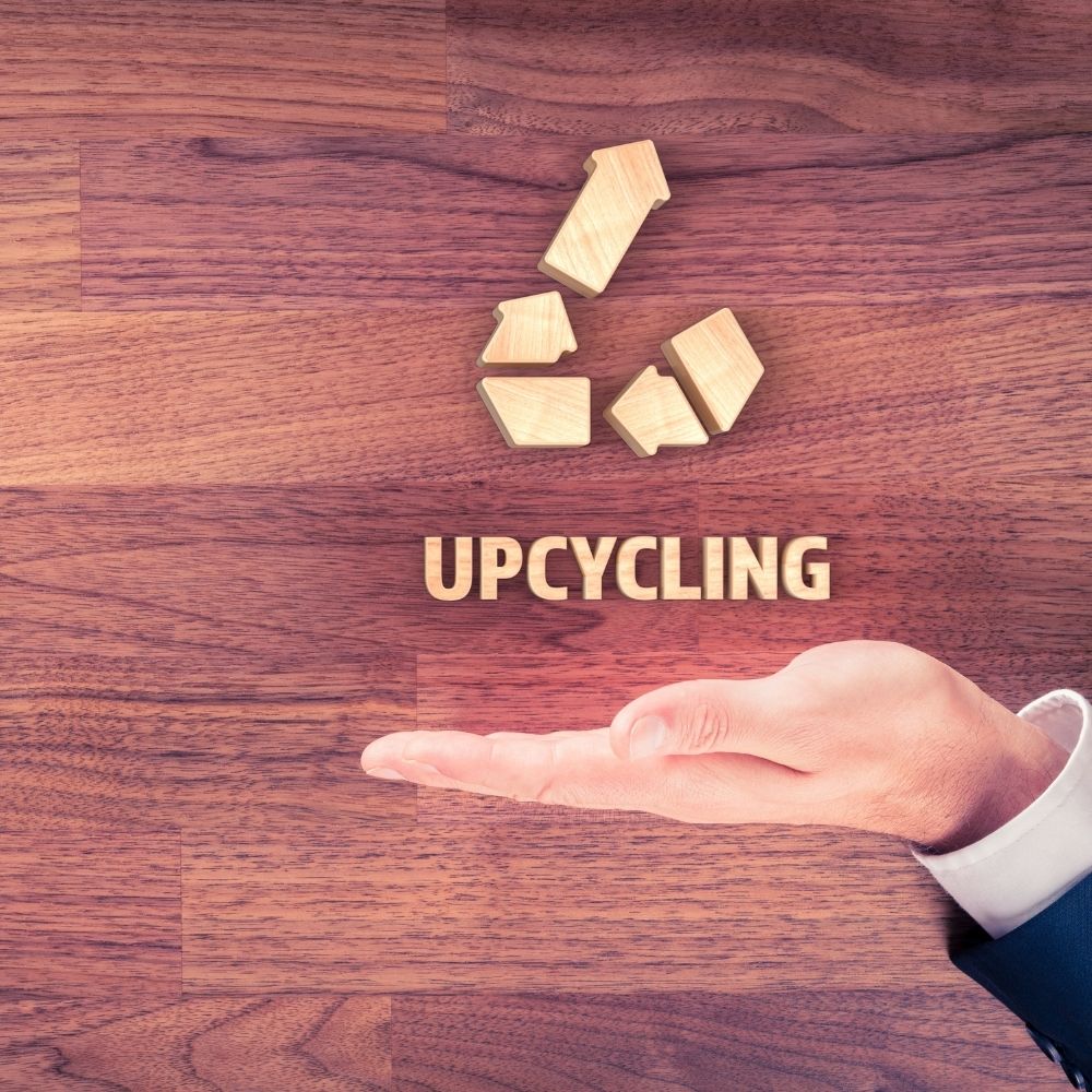 person with their hand under the word upcycling