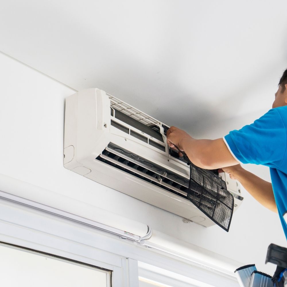 person working on an air conditioning unit