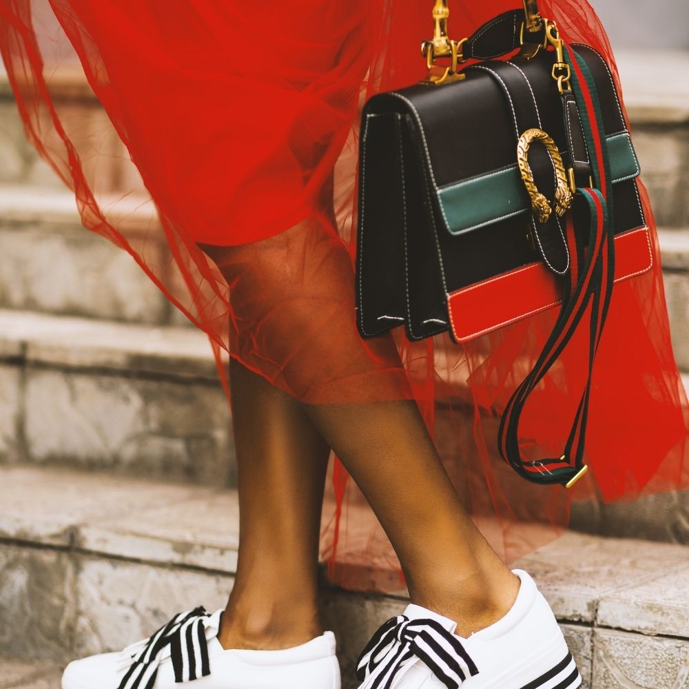 women wearing a red dress and holding a luxury handbag