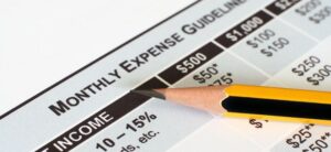 monthly expenses list with a pencil ontop