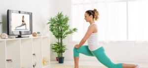 person doing yoga in their front room in front of a TV