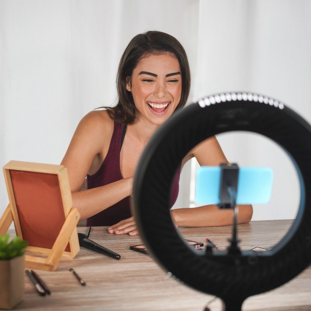 person filing a tiktok using a phone on a light stand