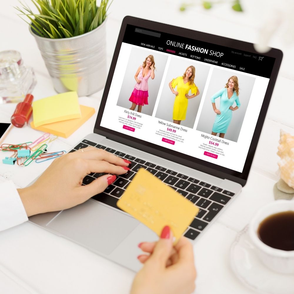 person holding a credit card shopping for clothes online