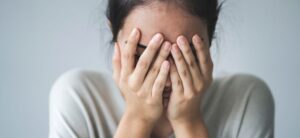 women with her hands over her face