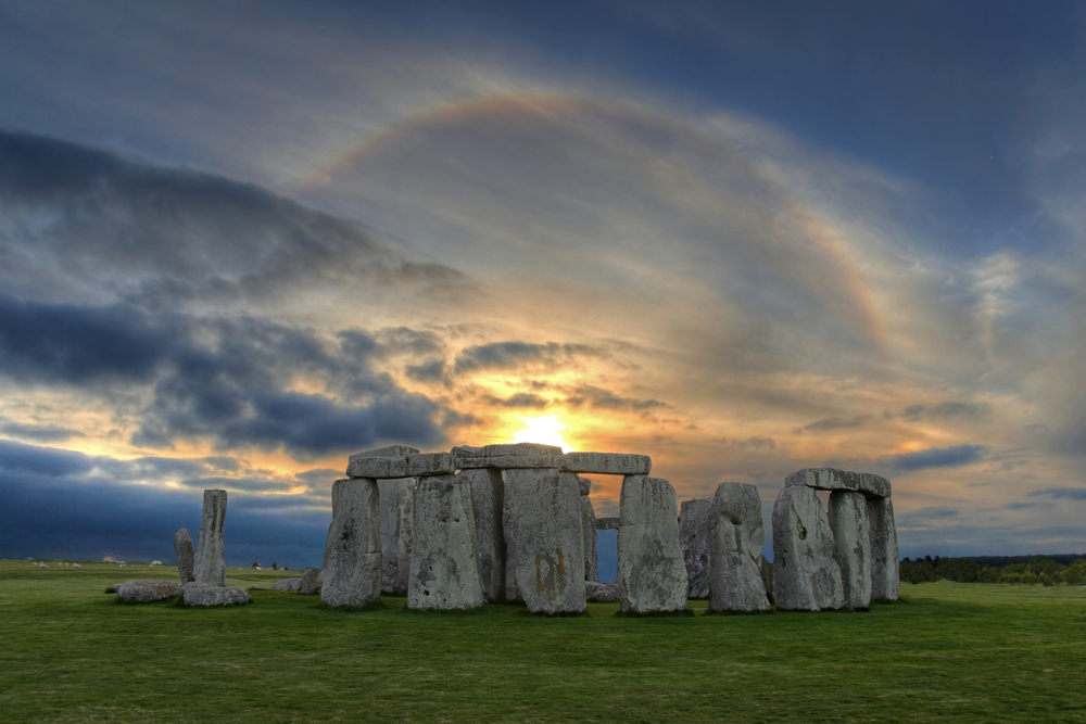 Image of Stonehenge at sunset with beautiful solar sunset halo in vibrant colors. A halo is an optical phenomenon that appears around the Sun and mostly caused by ice crystals in the upper troposphere.