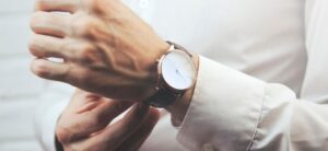 man wearing a white shirt with a watch around his wrist