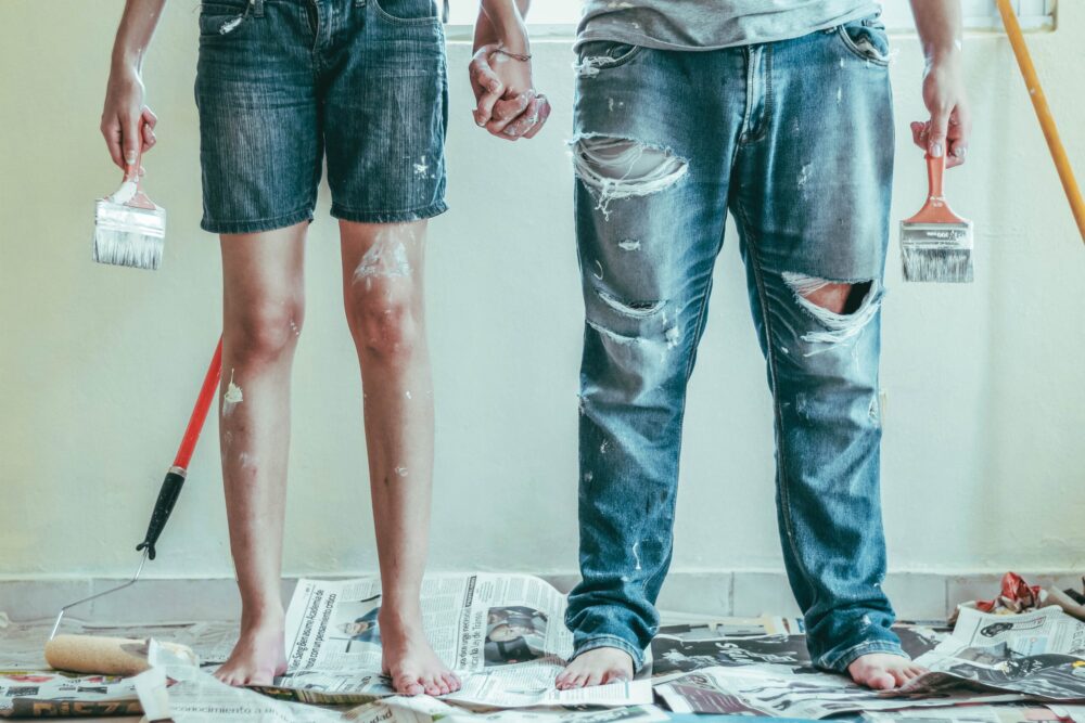 two people holding hands and paintbrushes