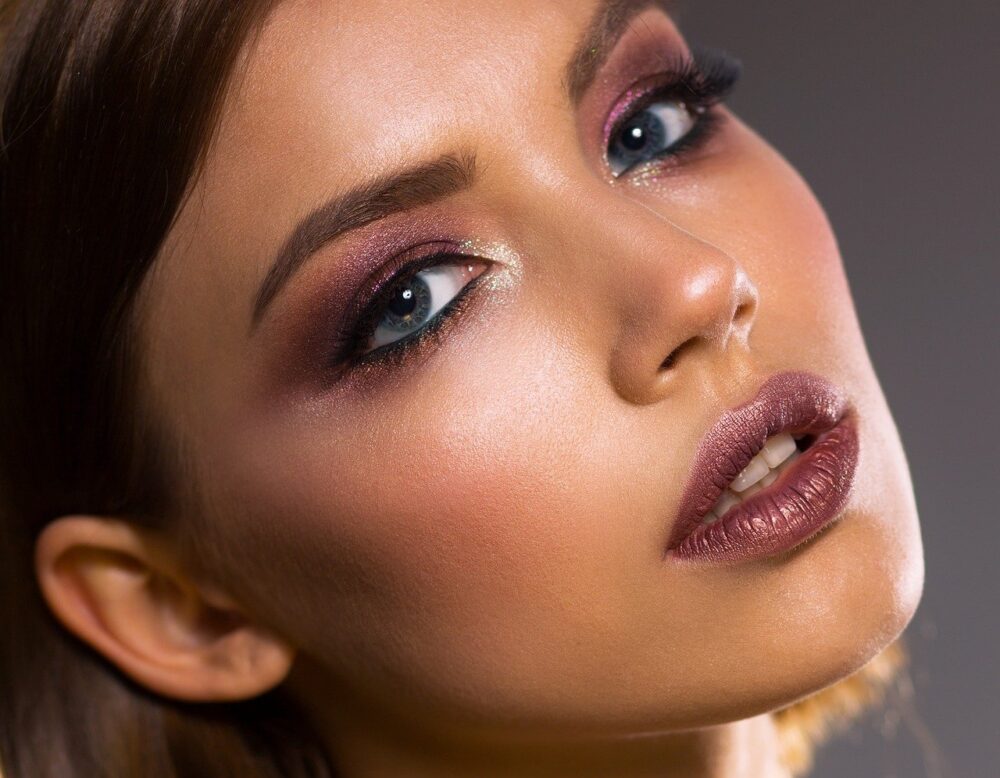 portrait of a womens face wearing makeip dark lip and eye