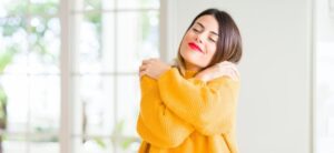 women wearing a yellow top and hugging herself
