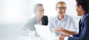people sat around a computer talking about business