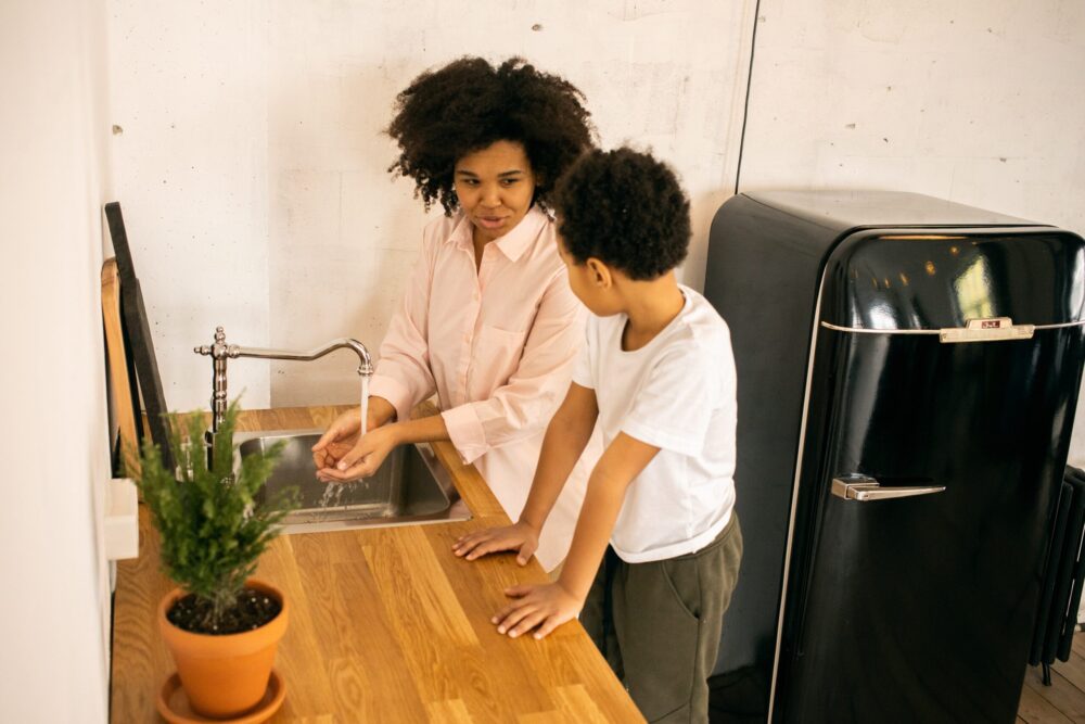 women and child washing their hands at a sink