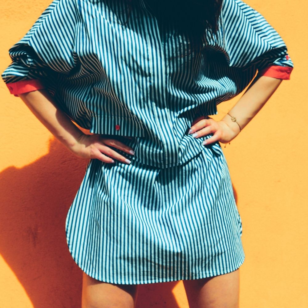 woman in a striped dress against a yellow backdrop