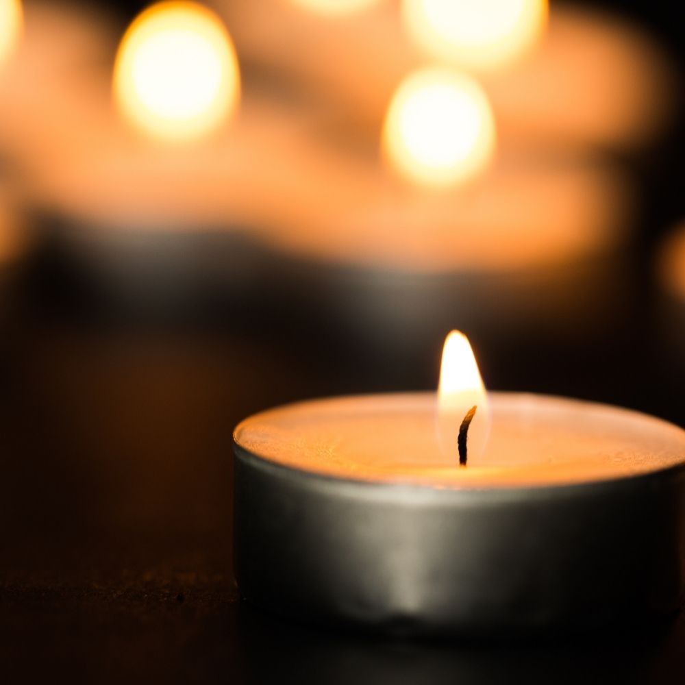 small candle burning with others in the background