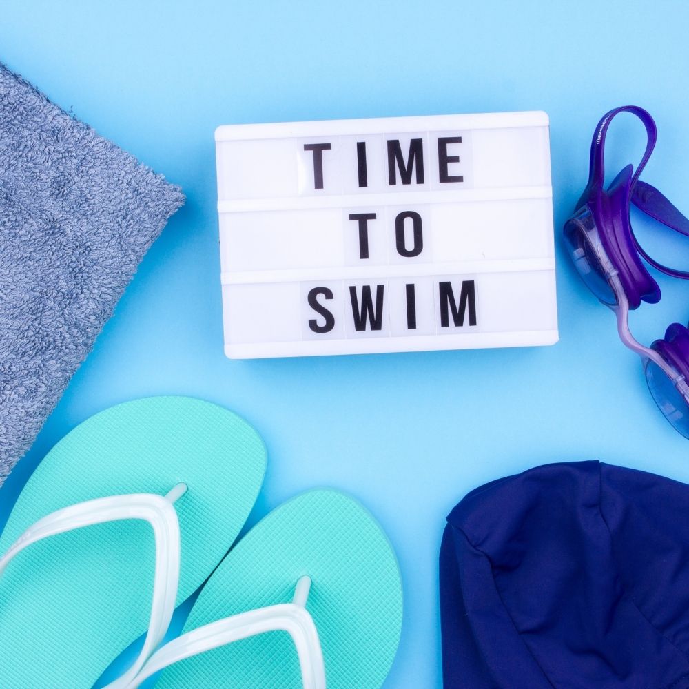 time to swim on a light box with swimming items around it