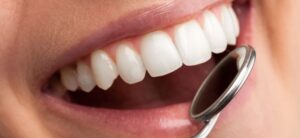 women having her teeth looked at with a dentist tool