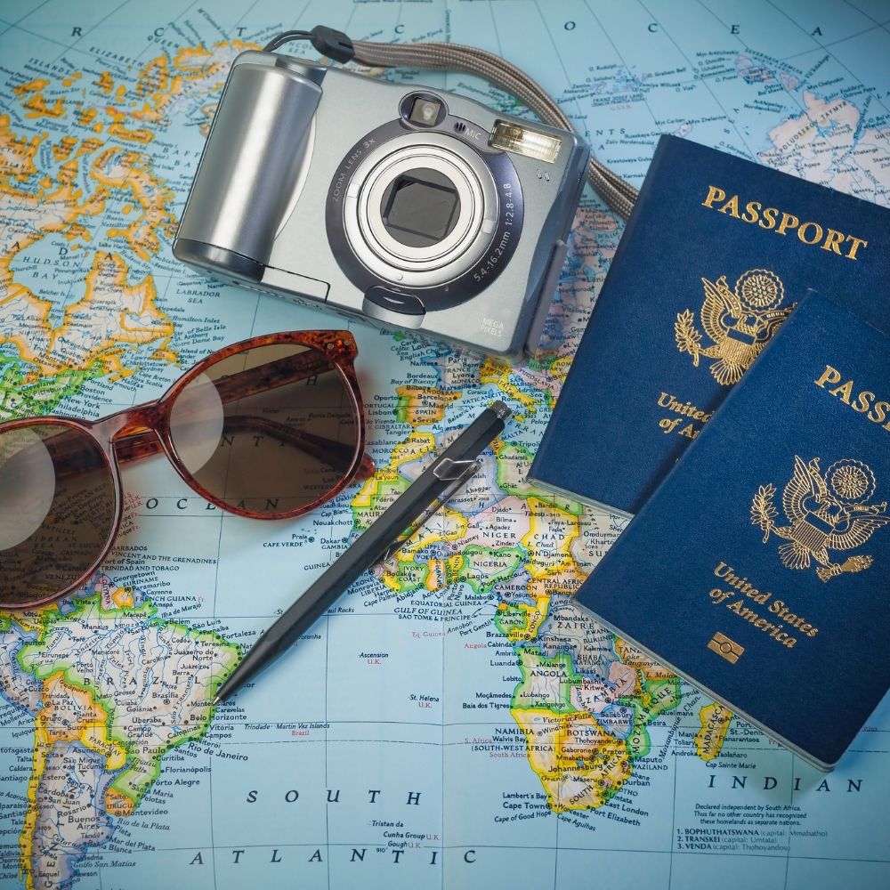 world map passport camera and sunglasses